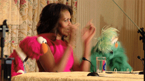 Michelle Obama doing a happy dance with the muppet characters
