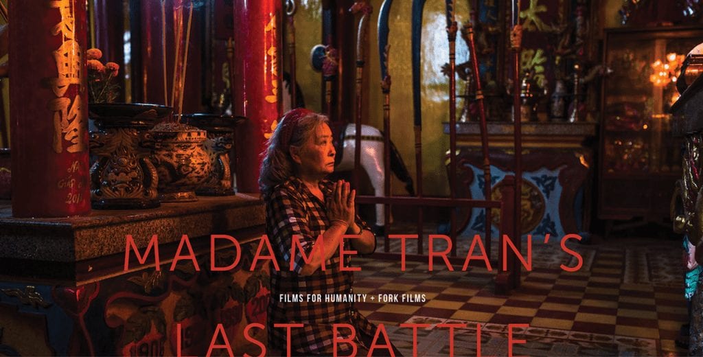 Front cover of a documentary pitch deck that shows a woman praying on the floor with the text "Madame Tran's Last Battle."