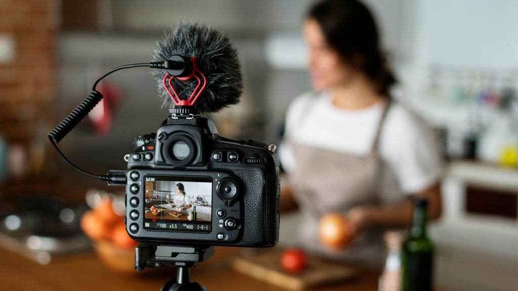 woman filming cooking video in kitchen